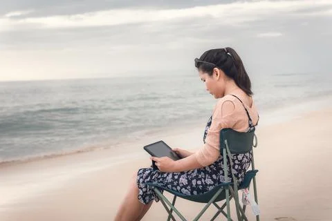Freelancer Woman is Working on Tablet While Travel Vacation Trip at The Beach Stock Photos