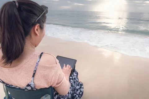 Freelancer Woman is Working on Tablet While Travel Vacation Trip at The Beach Stock Photos