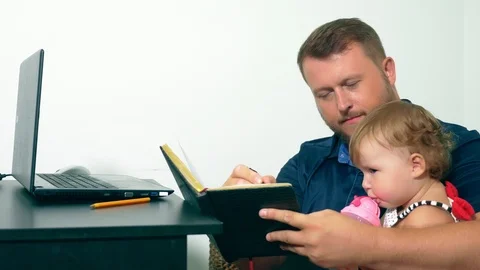 Freelancer work concept. Happy dad working at home with a laptop, holding the Stock Footage 102894755
