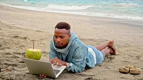 Freelancer work sunny beach. African american man type laptop Black guy near sea Stock Footage 246407350