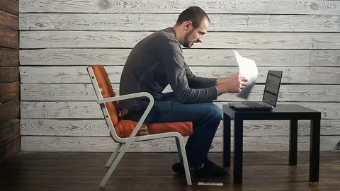 The freelancer working on the computer with the documents gets the bad news Stock Footage 83783445