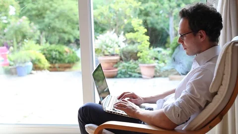 Freelancer working on computer from home and then looking at the window Video stock 98093643