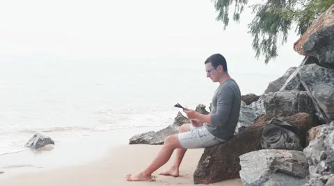 Freelancer working guy sitting on the beach with views of palm trees Stock Footage 61511192