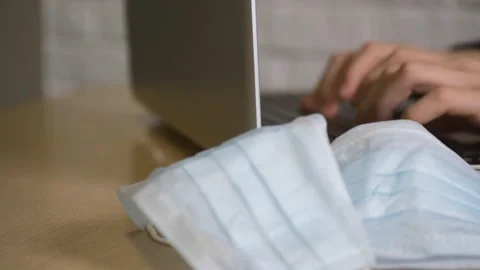 A freelancer working from home uses a computer to study online. Medical masks Stock Footage 131294565
