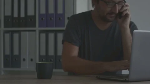 Freelancer working on laptop and using mobile phone Stock Footage
