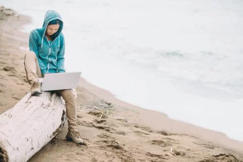 Freelancer working on laptop on beach Stock Photos