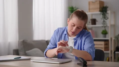 Freelancer working on laptop , closing it and sending voicemail on smartwatch. Stock Footage 232798677