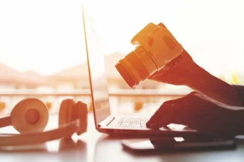 A freelancer working on laptop computer and holding DSLR Camera working from Stock Photos