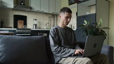 Freelancer working on laptop at home kitchen sofa remote work lifestyle concept Stock Footage 314516019