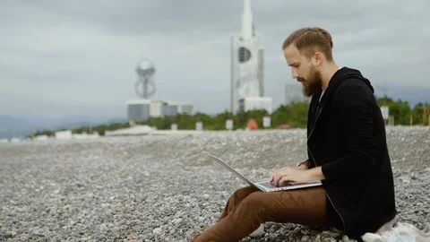 Freelancer working with a laptop on the seashore Stock Footage 100747260
