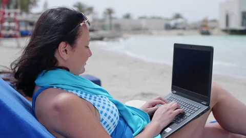 Freelancer working on laptop while resting at beach Stock Footage 249764700