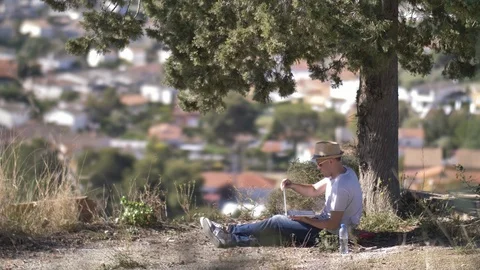 Freelancer working on a laptop while sitting in a park at outdoor Stock Footage 126278221
