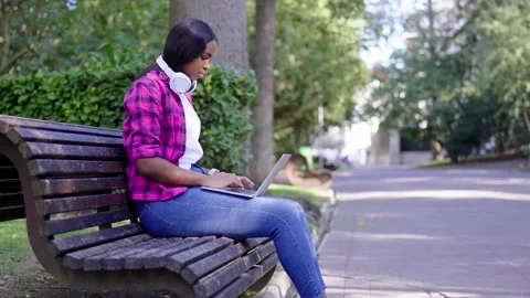 Freelancer working in a park on laptop Stock Footage 252568093