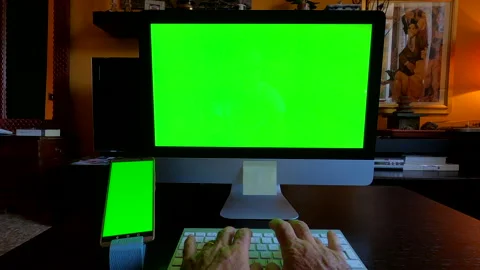 Freelancer working on personal computer and smartphone with green screen at home Stock Footage 138646158