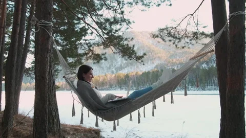 Freelancer working remotely from hammock in winter forest Stock Footage 303501064
