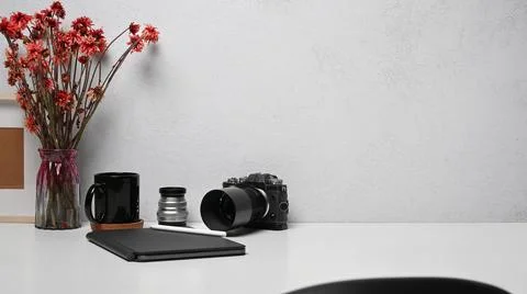 Freelancer workplace with camera, notebook, picture frame and flower pot on Stock Photos