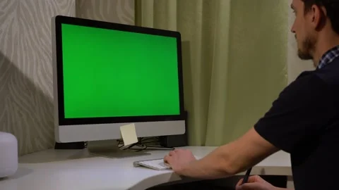 Freelancer works at a computer with a green screen Video stock 143109595