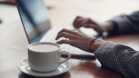 Freelancer works at a laptop while sitting in a cafe Stock Footage 144102950