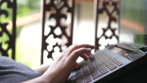 Freelancer works remotely by notebook, lying in hammock in a tropical garden Stock Footage 199594297