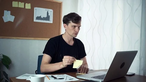 Freelancer writing ideas on adhesive notes and attaching it to board at office Video stock 79894812