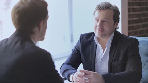 Freelancers having a conversation in front of a window sitting at the restaurant Stock Footage 130042965