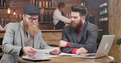 Freelancers with nice suits and beards agreeing over the reports of the company Stock Footage 104972690