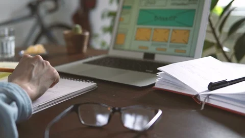 Freelancer's workplace. Web Developer makes sketches of the site in his notebook Stockbeeldmateriaal 88170926