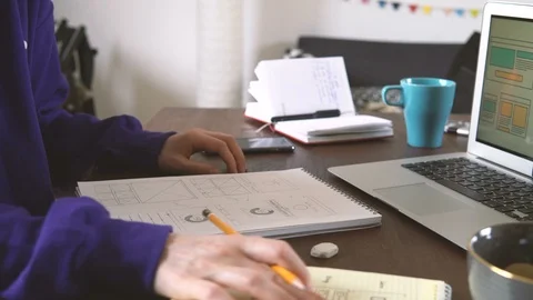 Freelancer's workplace. Web Developer makes sketches of the site in his notebook Video stock 88171640