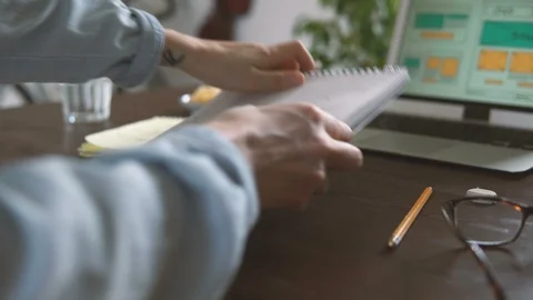 Freelancer's workplace. Web Developer makes sketches of the site in his notebook Video stock 88172667