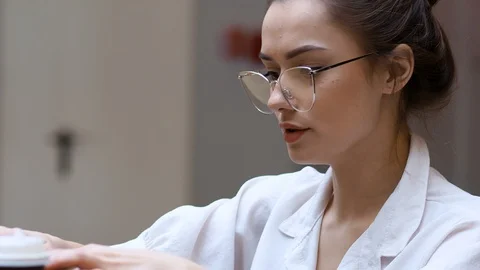 Freelancing and remote work. Young woman with glasses typing a letter on a Stock Footage 128992334