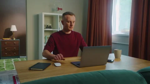 Freelancing man work at home sit table open computer laptop. Remote online job. Stock Footage 326428432