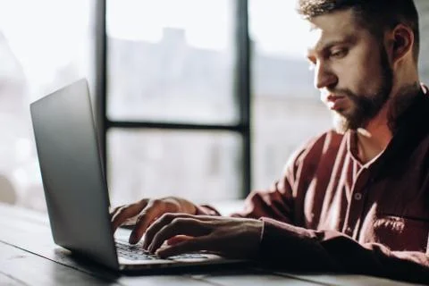 Freelancing, man working on laptop computer at home. Stock Photos