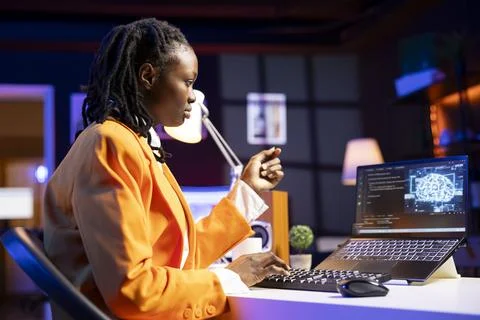 Freelancing system administrator upgrading high tech AI with laptop at home Stock Photos