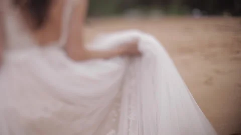 Freelensing slow motion of a bride walking on the beach carrying her wedding Stock Footage 135212876