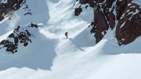 Freeride snowboarder making his way through rocky terrain in Andes mountains Stock Footage 121597764