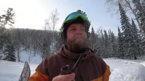 Freerider with a beard smokes a real pipe in the winter forest Stock Footage 98962992