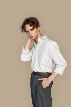 Freestyle. Man in formal wear standing isolated on gray hand in pocket posing Stock Photos