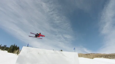 Freestyle skier jumping and spinning off of a jump in the terrain park Stock Footage 113202018