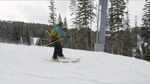 Freestyle skier jumping off a snowy ridge performing a 360 Stock Footage 113204553