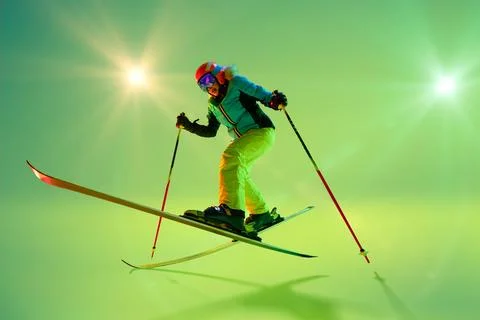 Freestyle skier mid-air, executing dynamic jump with bent knees and balanced Stock Photos