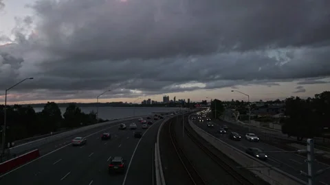 Freeway traffic and train line at dusk. City, river in background. Timelapse. Stock Footage 252057864