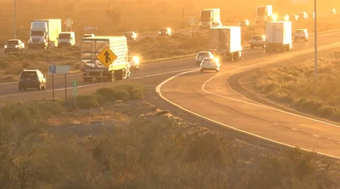 Freeway traffic driving toward bright sunset Stock Footage 61221271