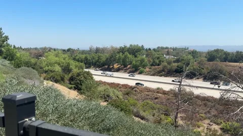 Freeway traffic seen through dry hillside brush, Los Angeles Video stock 344083310