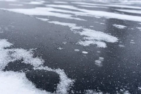Freeze bubbles in solid layer of ice of a frozen river Stock Photos