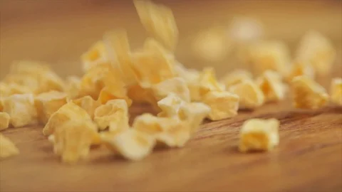 Freeze-dried Mango Cubes falling on Wooden Table Closeup 動画素材 99163793