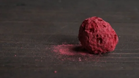 Freeze-Dried Raspberry Falling onto a Dark Table Closeup No. 1 Stock Footage 99162897