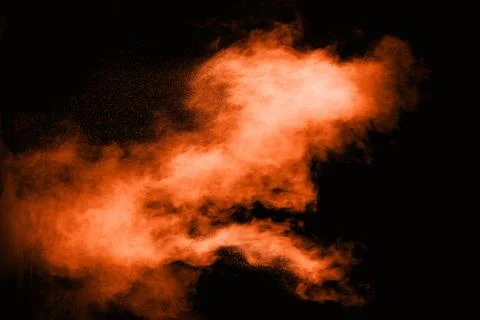 Freeze motion of orange powder exploding  on black background. Stock Photos