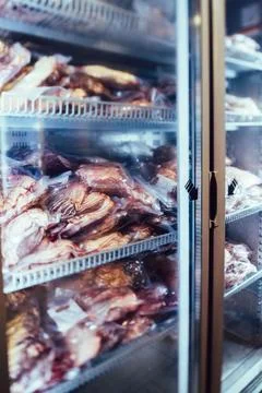 Freezer with a selection of assorted raw meat products within. Stock Photos