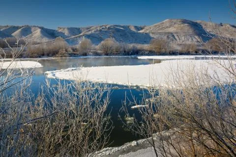 Freezing river from the hilly banks and large ice floes. A sunny day with a c Stock Photos