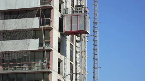 Freight elevator at the construction site of a tall building rides up and down Stock Footage 172484796